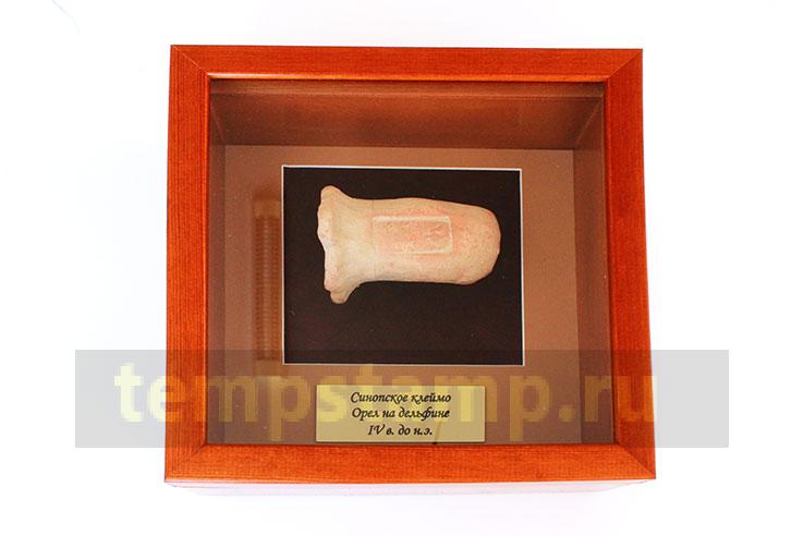 "A handle from an amphora with a Synop brand "An eagle on a dolphin" (in a frame)"